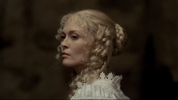 Movie still from “The Four Musketeers: Milady's Revenge” (1974), directed by Richard Lester – A woman in a white dress with long blonde curly hair; Close Up shot, Low angle