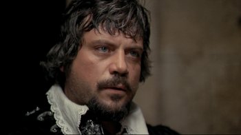 Movie still from “The Four Musketeers: Milady's Revenge” (1974), directed by Richard Lester – A person with a beard; Close Up shot, Over the shoulder angle