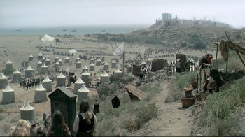 Movie still from “The Four Musketeers: Milady's Revenge” (1974), directed by Richard Lester – A group of people standing on top of a sandy beach; Extreme Wide shot, High angle