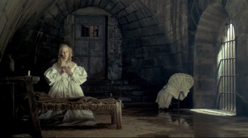 Movie still from “The Four Musketeers: Milady's Revenge” (1974), directed by Richard Lester – A woman in a white dress sitting on a bench; Wide shot, High angle