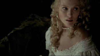 Movie still from “The Four Musketeers: Milady's Revenge” (1974), directed by Richard Lester – A woman in a white dress and a pearl necklace; Close Up shot, Over the shoulder angle