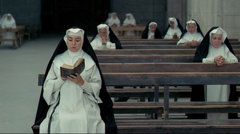 Movie still from “The Four Musketeers: Milady's Revenge” (1974), directed by Richard Lester – A nun is reading a book in front of a group of people; Wide shot, High angle