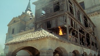 Movie still from “The Four Musketeers: Milady's Revenge” (1974), directed by Richard Lester – A fire is burning in the middle of a building; Extreme Wide shot, Low angle