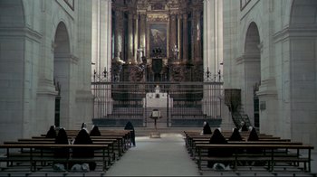 Movie still from “The Four Musketeers: Milady's Revenge” (1974), directed by Richard Lester – A group of people sitting in front of an altar in a church; Extreme Wide shot, High angle