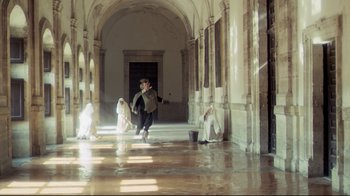 Movie still from “The Four Musketeers: Milady's Revenge” (1974), directed by Richard Lester – A man and two women in a hallway with pillars; Extreme Wide shot, High angle