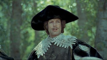 Movie still from “The Four Musketeers: Milady's Revenge” (1974), directed by Richard Lester – A person wearing a hat; Medium shot, Low angle