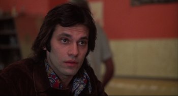 Movie still from “The Friends of Eddie Coyle” (1973), directed by Peter Yates – A person with long brown hair; Close Up shot, Low angle