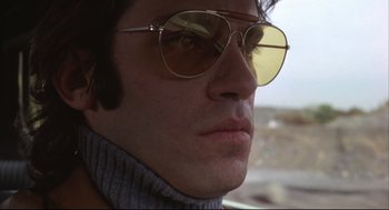 Movie still from “The Friends of Eddie Coyle” (1973), directed by Peter Yates – A person wearing sunglasses; Close Up shot, Low angle