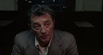 Movie still from “The Friends of Eddie Coyle” (1973), directed by Peter Yates – A person wearing a suit and tie; Close Up shot, Over the shoulder angle