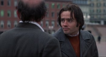 Movie still from “The Friends of Eddie Coyle” (1973), directed by Peter Yates – A man with long dark hair is talking to another man; Close Up shot, Over the shoulder angle