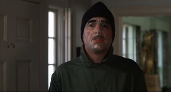 Movie still from “The Friends of Eddie Coyle” (1973), directed by Peter Yates – A man wearing a green jacket and a black hat; Close Up shot, Low angle