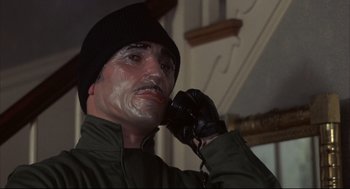 Movie still from “The Friends of Eddie Coyle” (1973), directed by Peter Yates – A man in a black hat is talking on a phone; Close Up shot, Low angle