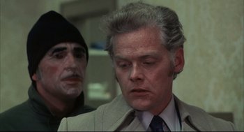 Movie still from “The Friends of Eddie Coyle” (1973), directed by Peter Yates – A man in a suit and tie next to another man in a suit and tie; Close Up shot, Over the shoulder angle