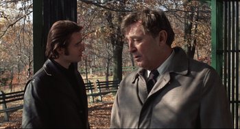 Movie still from “The Friends of Eddie Coyle” (1973), directed by Peter Yates – Two men are talking in a park in the fall; Close Up shot, Over the shoulder angle
