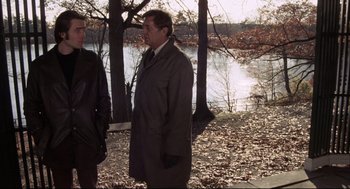 Movie still from “The Friends of Eddie Coyle” (1973), directed by Peter Yates – A man in a suit standing next to another man in a suit; Medium shot, Over the shoulder angle