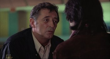 Movie still from “The Friends of Eddie Coyle” (1973), directed by Peter Yates – An older man talking to a younger man in front of a building; Close Up shot, Over the shoulder angle