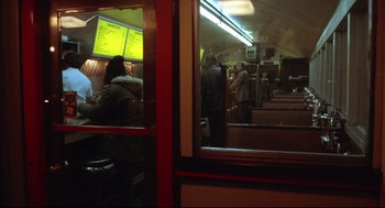 Movie still from “The Friends of Eddie Coyle” (1973), directed by Peter Yates – A group of people sitting at a table in front of a television; Wide shot, High angle