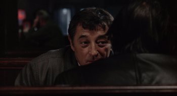 Movie still from “The Friends of Eddie Coyle” (1973), directed by Peter Yates – A person sitting in front of another person; Close Up shot, Over the shoulder angle