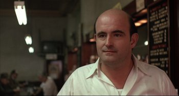 Movie still from “The Friends of Eddie Coyle” (1973), directed by Peter Yates – A man with a bald head is looking at the camera; Close Up shot, Over the shoulder angle