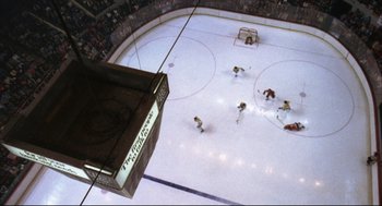 Movie still from “The Friends of Eddie Coyle” (1973), directed by Peter Yates – A view from above of a hockey rink with players on the ice; Extreme Wide shot, Overhead angle