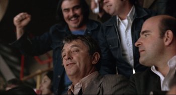 Movie still from “The Friends of Eddie Coyle” (1973), directed by Peter Yates – A group of men sitting next to each other in a room; Medium shot, Low angle