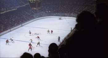 Movie still from “The Friends of Eddie Coyle” (1973), directed by Peter Yates – A group of men playing a game of hockey on a rink; Extreme Wide shot, High angle