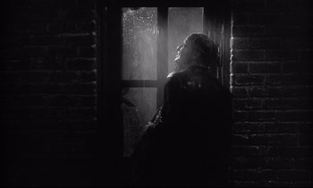 Movie still from “The Fugitive Kind” (1960), directed by Sidney Lumet – A woman standing next to a brick wall; Medium shot, Low angle