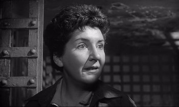 Movie still from “The Fugitive Kind” (1960), directed by Sidney Lumet – An older woman with short curly hair wearing a jacket; Close Up shot, Low angle