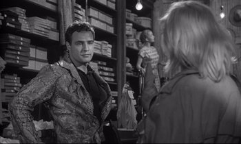 Movie still from “The Fugitive Kind” (1960), directed by Sidney Lumet – A man and a woman are talking in a store; Medium shot, Over the shoulder angle