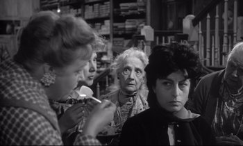 Movie still from “The Fugitive Kind” (1960), directed by Sidney Lumet – A group of people sitting in front of a store; Close Up shot, Over the shoulder angle