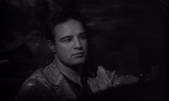 Movie still from “The Fugitive Kind” (1960), directed by Sidney Lumet – Black and white photograph of a man looking at the camera; Close Up shot, Over the shoulder angle