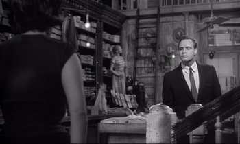 Movie still from “The Fugitive Kind” (1960), directed by Sidney Lumet – A man and a woman are standing in a store; Medium shot, Over the shoulder angle
