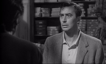 Movie still from “The Fugitive Kind” (1960), directed by Sidney Lumet – A black and white photo of a man in a suit; Close Up shot, Over the shoulder angle