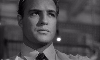 Movie still from “The Fugitive Kind” (1960), directed by Sidney Lumet – Black and white photograph of a man in a dress shirt and tie; Close Up shot, Low angle