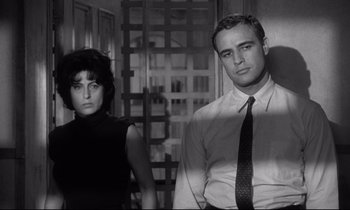 Movie still from “The Fugitive Kind” (1960), directed by Sidney Lumet – A man and a woman standing next to each other in a room; Medium shot, Low angle