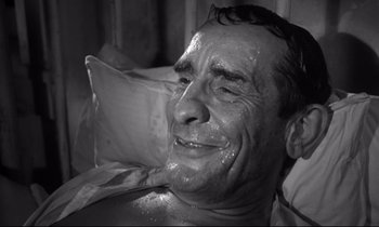 Movie still from “The Fugitive Kind” (1960), directed by Sidney Lumet – An older man laying in a bed smiling; Close Up shot, High angle