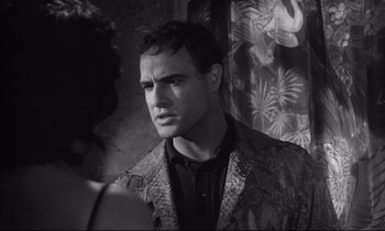 Movie still from “The Fugitive Kind” (1960), directed by Sidney Lumet – A black and white photo of a man in a suit; Close Up shot, Over the shoulder angle