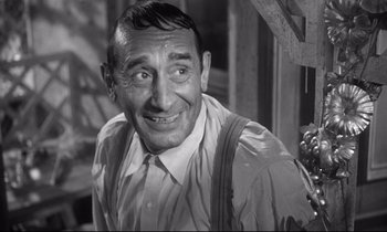 Movie still from “The Fugitive Kind” (1960), directed by Sidney Lumet – An old black and white photo of a man smiling; Close Up shot, Low angle