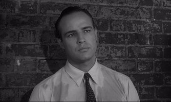 Movie still from “The Fugitive Kind” (1960), directed by Sidney Lumet – Black and white photograph of a man wearing a shirt and tie; Close Up shot, Low angle