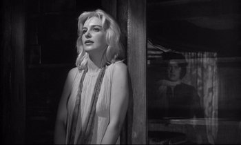 Movie still from “The Fugitive Kind” (1960), directed by Sidney Lumet – Black and white photograph of a woman in front of a window; Medium shot, Over the shoulder angle