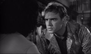 Movie still from “The Fugitive Kind” (1960), directed by Sidney Lumet – A black and white photo of a man looking at the camera; Close Up shot, Over the shoulder angle