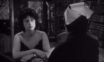 Movie still from “The Fugitive Kind” (1960), directed by Sidney Lumet – A black and white photo of a woman sitting in front of another woman; Close Up shot, Over the shoulder angle