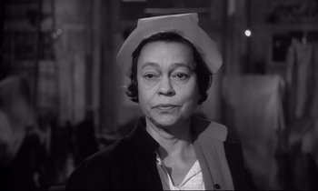 Movie still from “The Fugitive Kind” (1960), directed by Sidney Lumet – An older woman wearing a white hat and a black jacket; Close Up shot, High angle