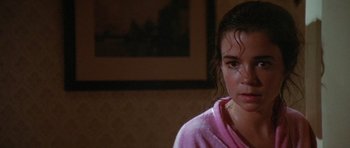 Movie still from “The Funhouse” (1981), directed by Tobe Hooper – A young girl in a pink shirt and a picture on the wall; Close Up shot, High angle