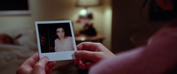 Movie still from “The Funhouse” (1981), directed by Tobe Hooper – A person holding a polaroid of a young boy; Extreme Close Up shot, High angle