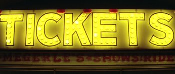 Movie still from “The Funhouse” (1981), directed by Tobe Hooper – A neon sign that says " ticket " on the side of a building; Extreme Close Up shot, Low angle
