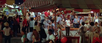 Movie still from “The Funhouse” (1981), directed by Tobe Hooper – A group of people standing around in a tent; Wide shot, High angle