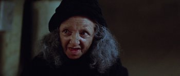 Movie still from “The Funhouse” (1981), directed by Tobe Hooper – An old woman with grey hair and a black hat; Close Up shot, Low angle