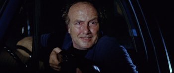 Movie still from “The Funhouse” (1981), directed by Tobe Hooper – A person holding a camera in the dark; Close Up shot, Low angle