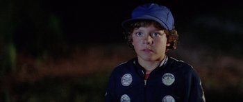 Movie still from “The Funhouse” (1981), directed by Tobe Hooper – A young boy wearing a blue hat and a jacket; Close Up shot, Over the shoulder angle